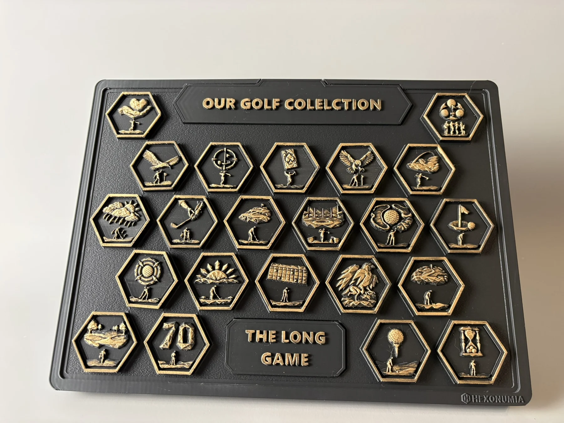 Front view of the physical Hexonumia Golf display showing hand-finished relief pieces
