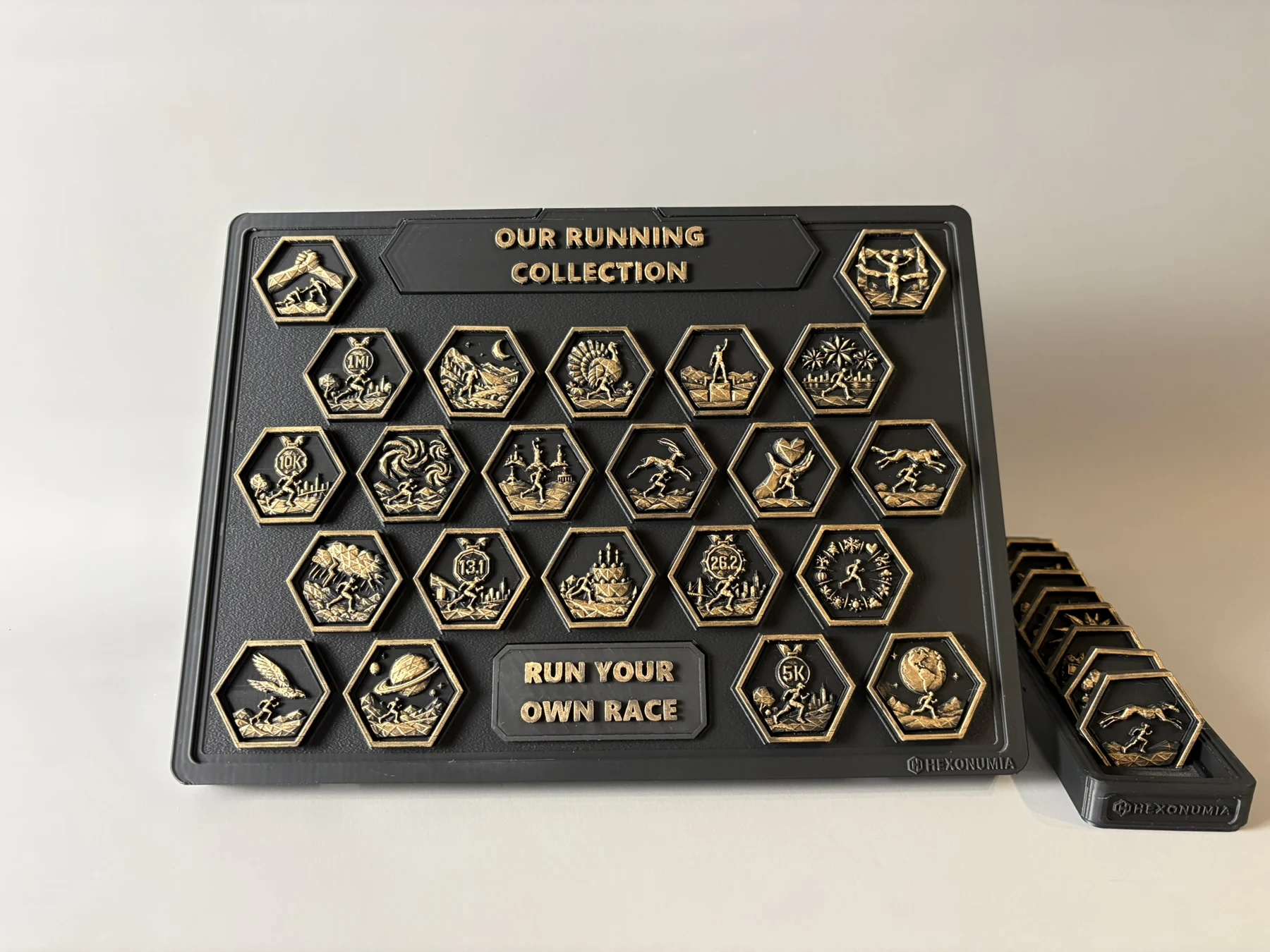 Physical Hexonumia Running collection with a 22-position display, hand-finished achievement pieces and companion vault